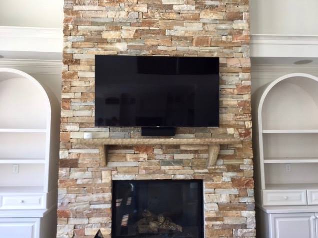 TV and Soundbar Mounted on Stone Fireplace Wall